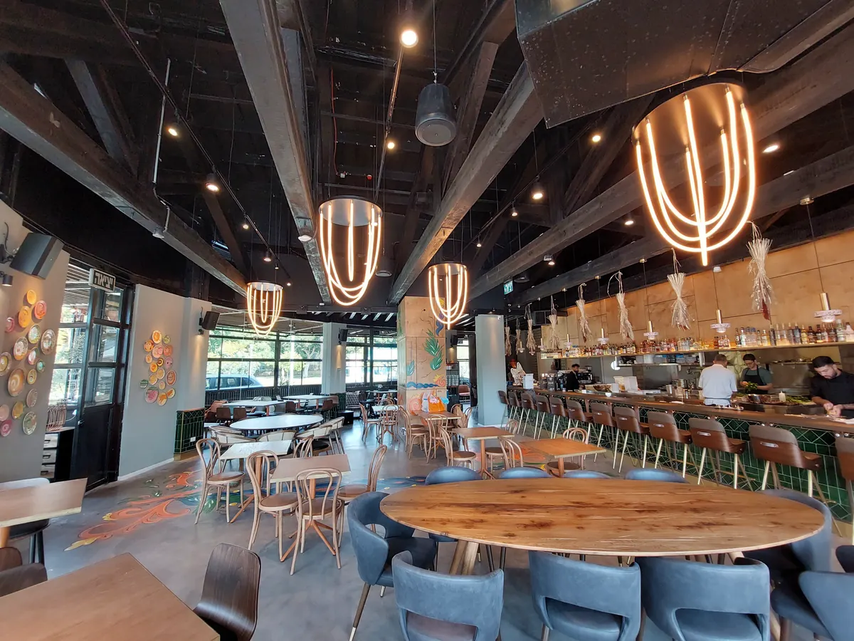 חלל מסעדה עם גופי תאורה תלויים גדולים מלולאות אור